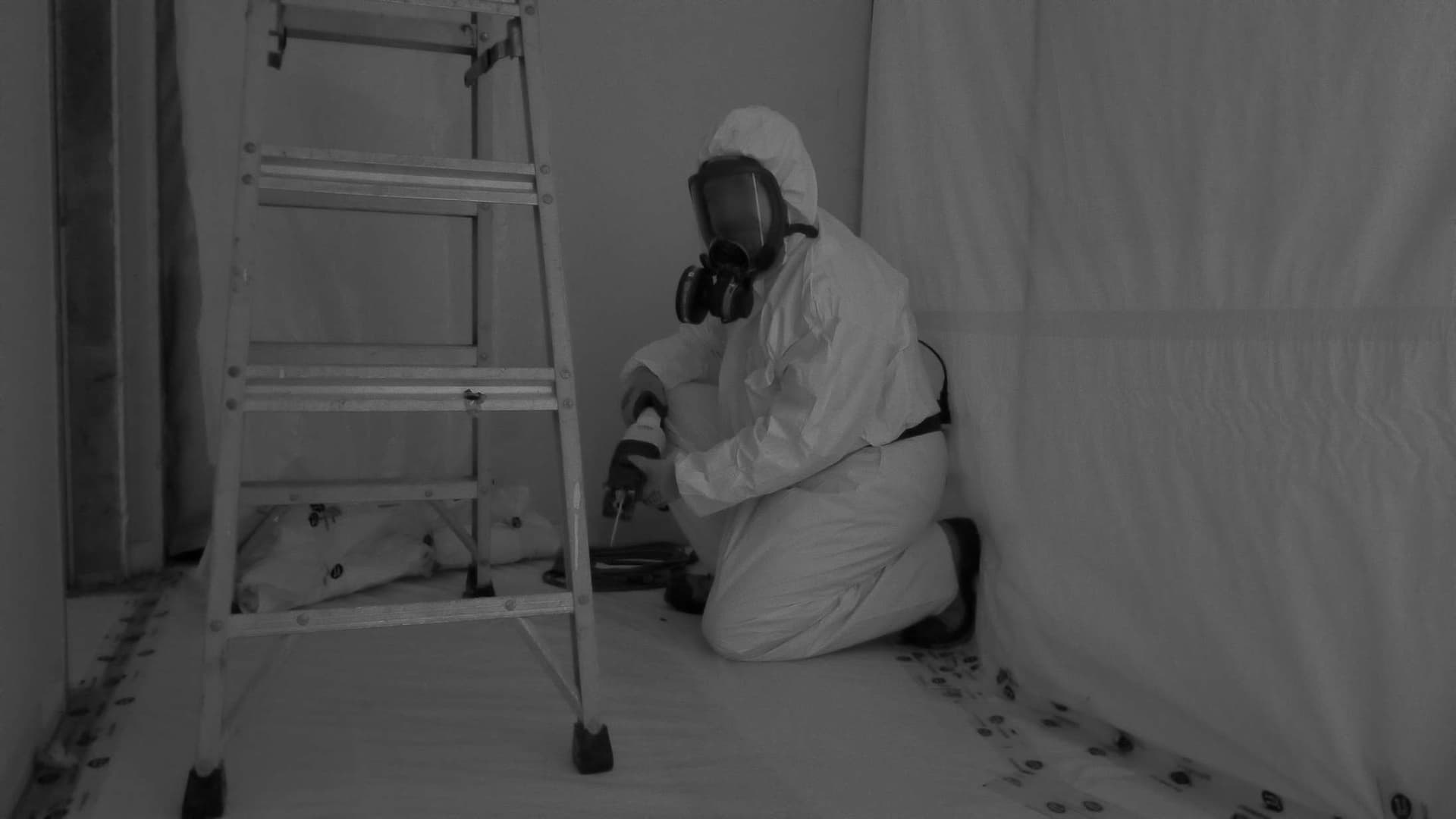 Asbestos containment area with poly sheeting, negative air machines, and decontamination chambers set up by certified technicians