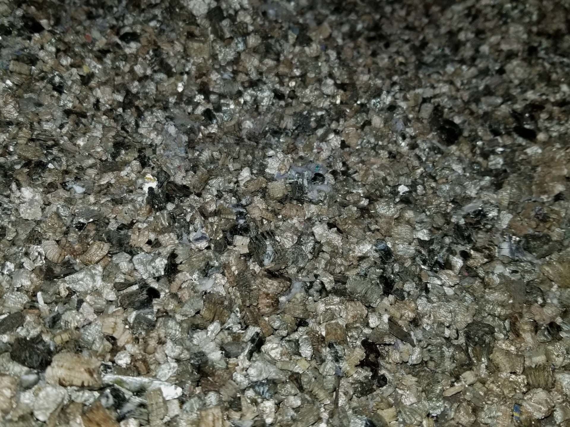 Vermiculite insulation in an attic that requires professional testing and potential asbestos abatement