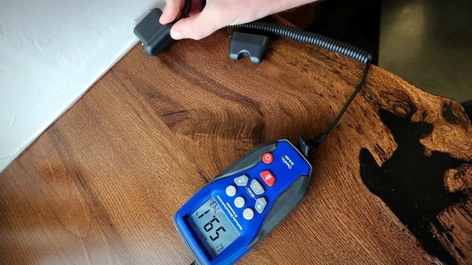 Relief Restorations inspector taking a moisture reading with a calibrated meter during a Winnipeg mould inspection