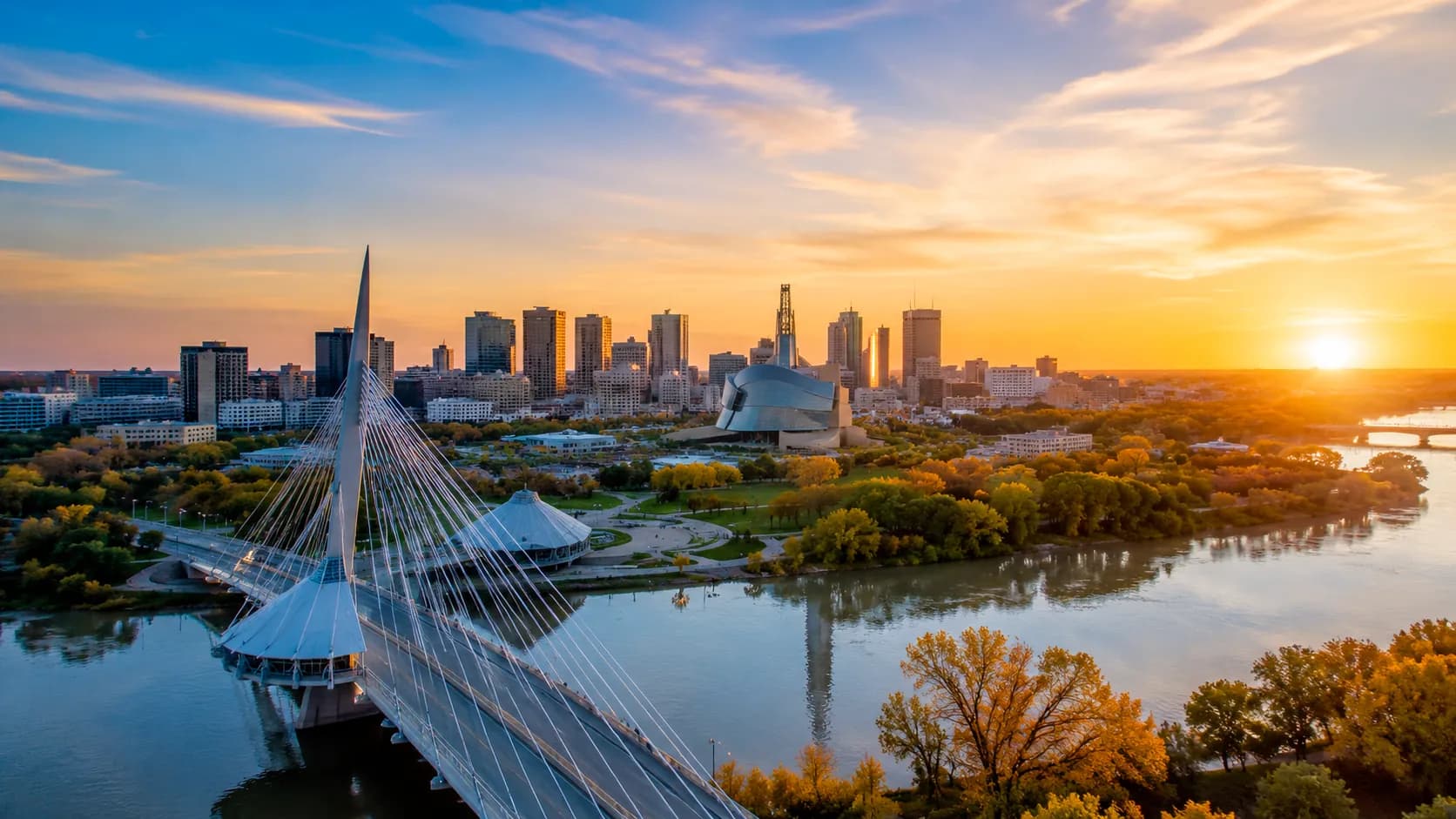 Aerial view of the Winnipeg skyline at sunset with the Esplanade Riel bridge and the Red River, the heart of Relief Restorations' service area