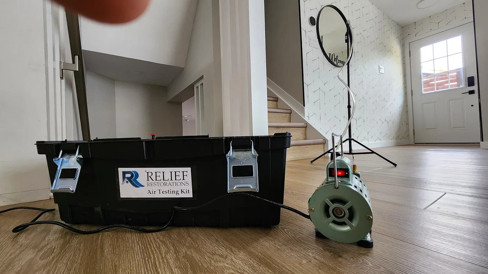 Relief Restorations air testing kit and calibrated spore-sampling pump set up inside a Winnipeg home for mould air quality testing