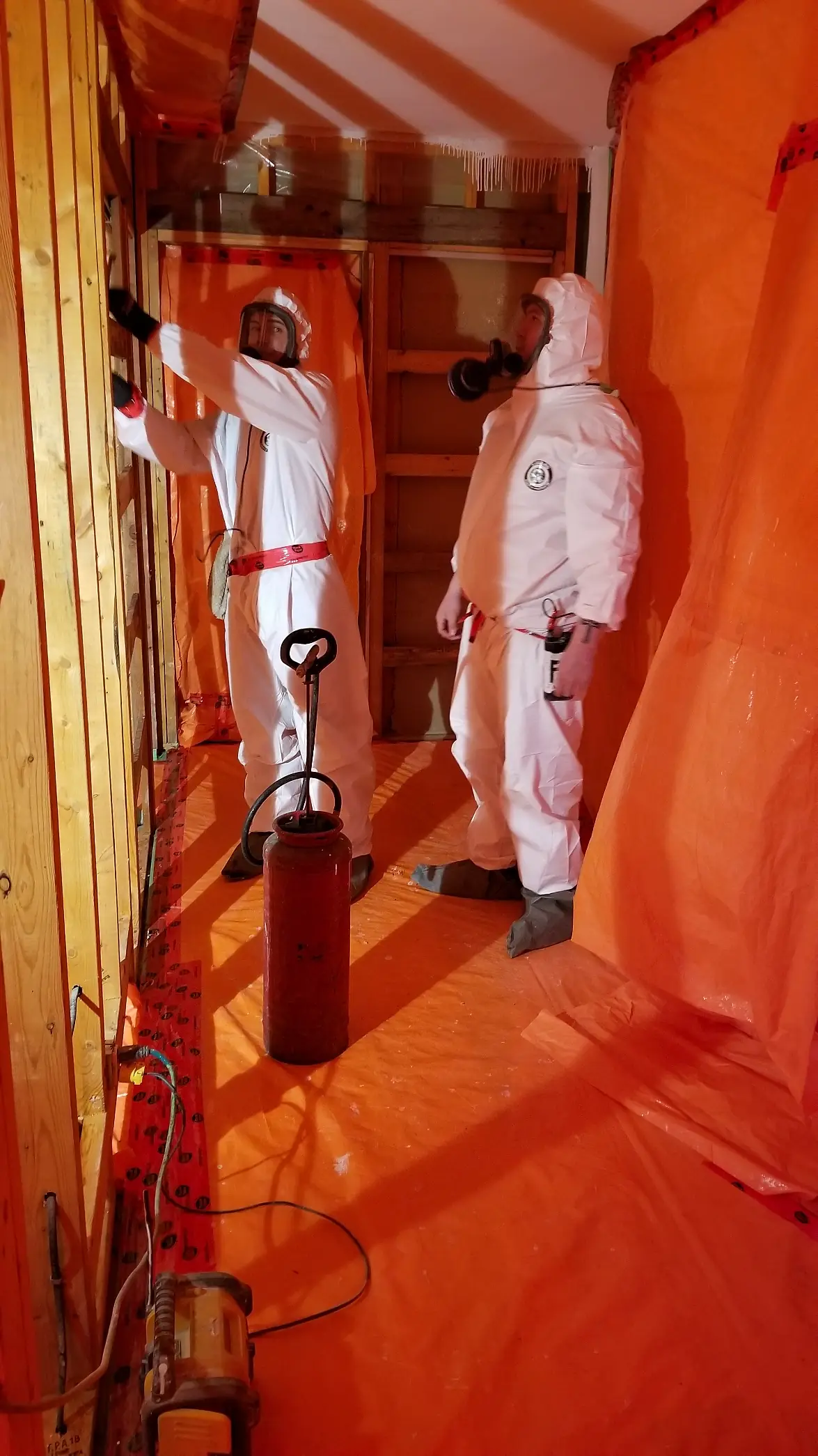 Relief Restorations technicians in protective suits working inside sealed containment
