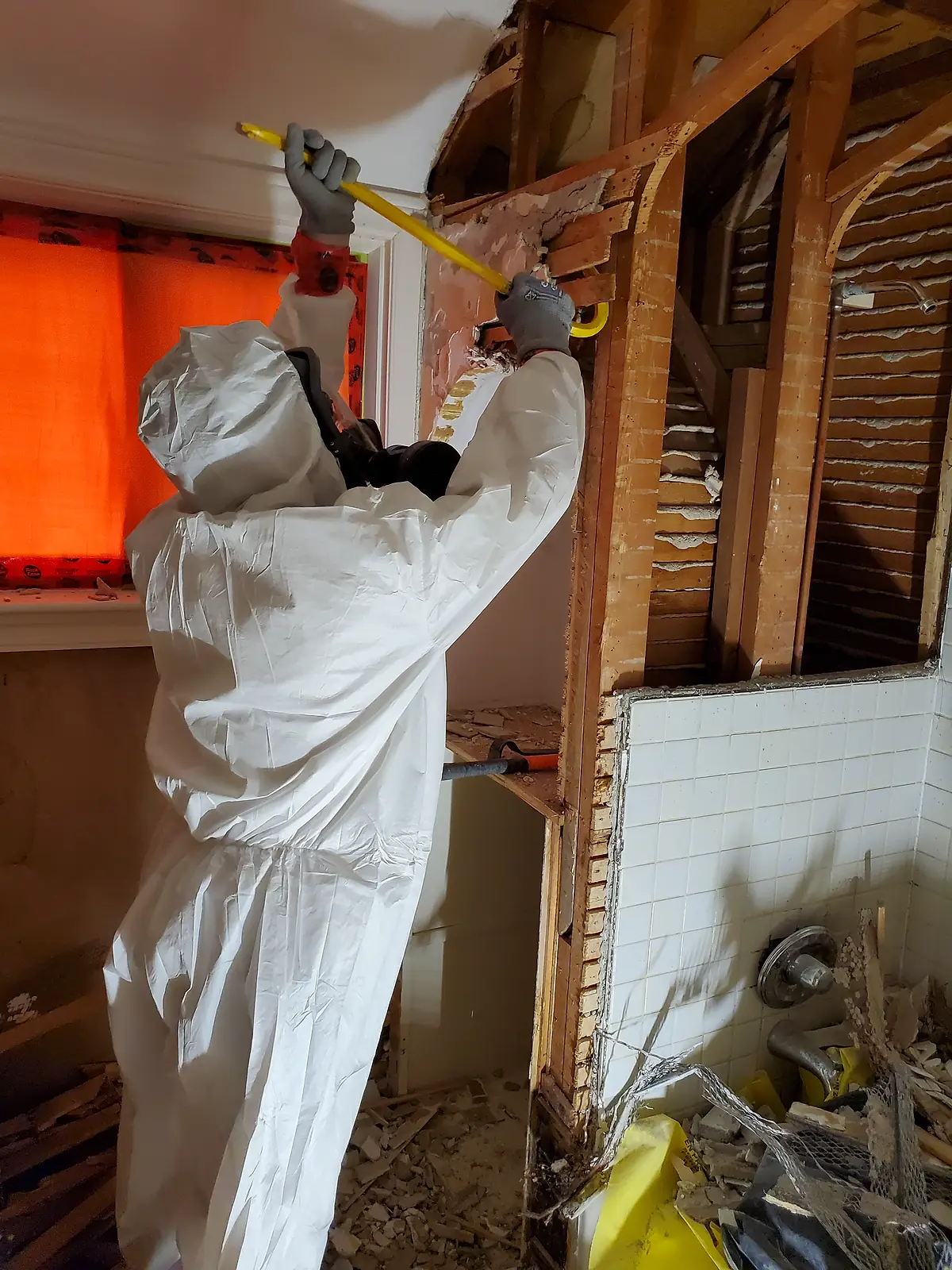 Technicians removing damaged material from a ceiling during remediation