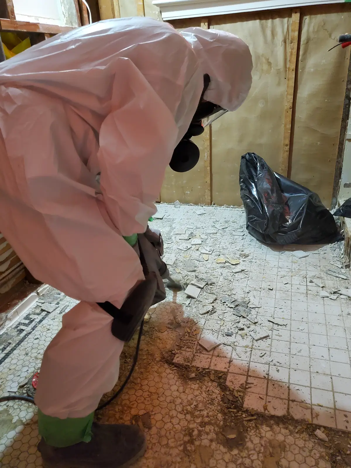 Technician bagging contaminated material under containment