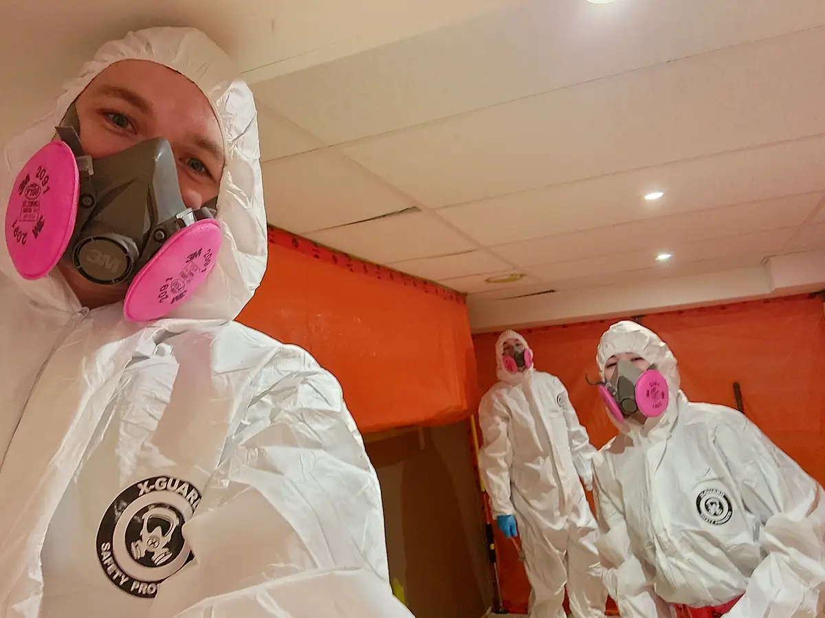 Certified Relief Restorations technicians in respirators inside a sealed work area