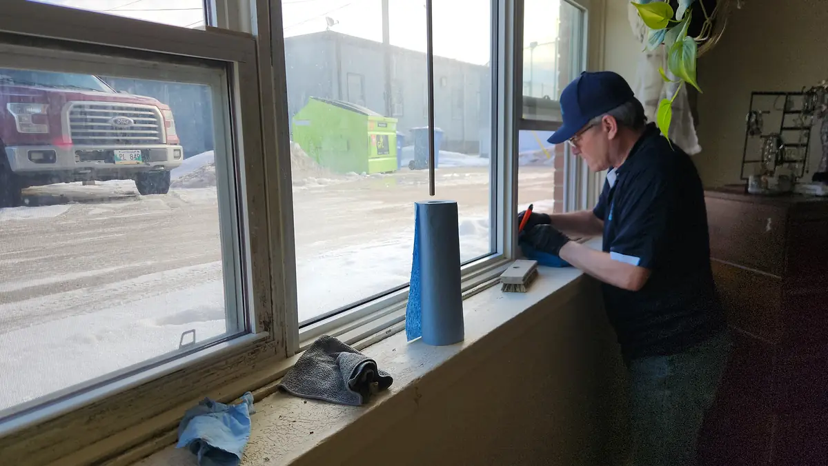 Technician performing a property inspection at a window