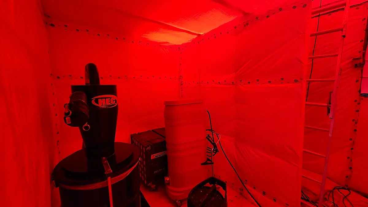 Cyclone HEPA vacuum running in a sealed containment