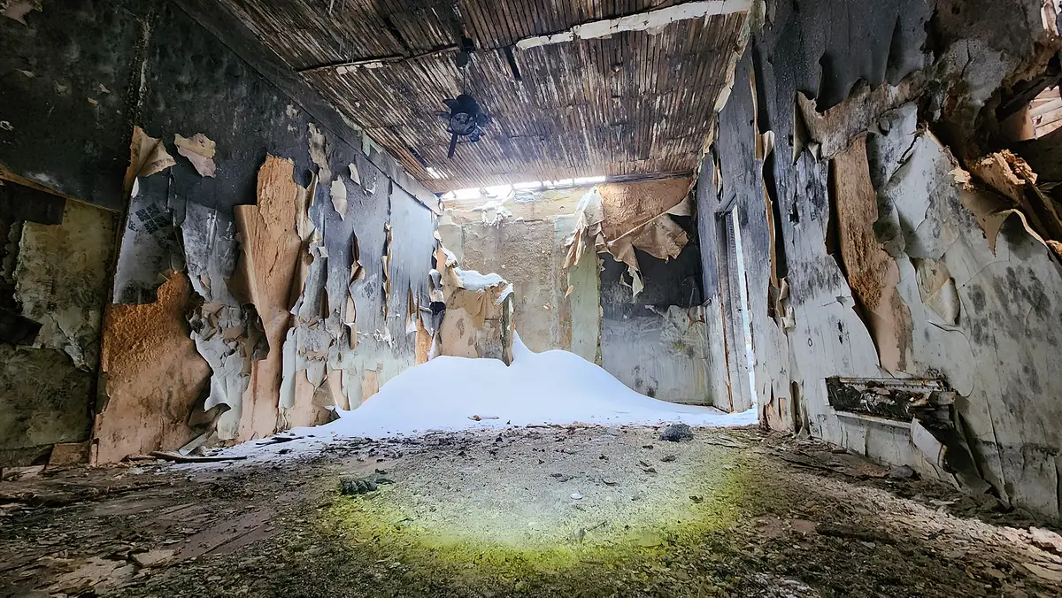 Insulation and debris being cleared from a crawlspace
